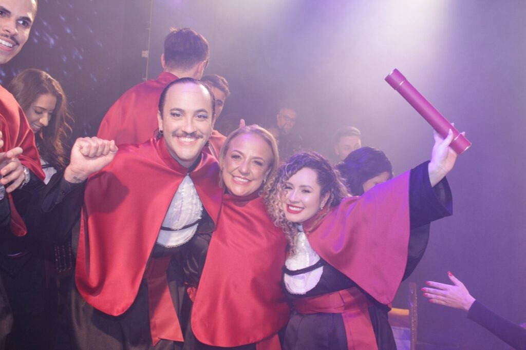 Formandos celebrando com canudos e becas vermelhas